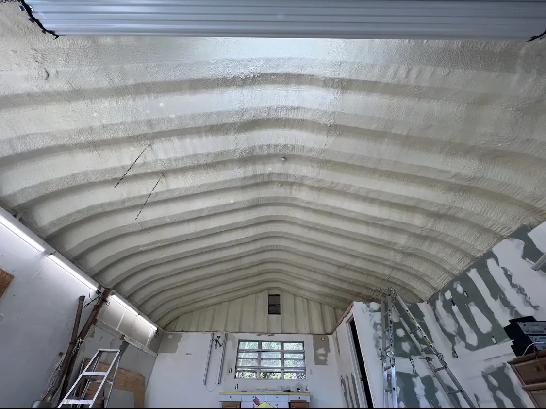 Spray polyurethane foam applied to the underside of a metal roof deck in Cuero